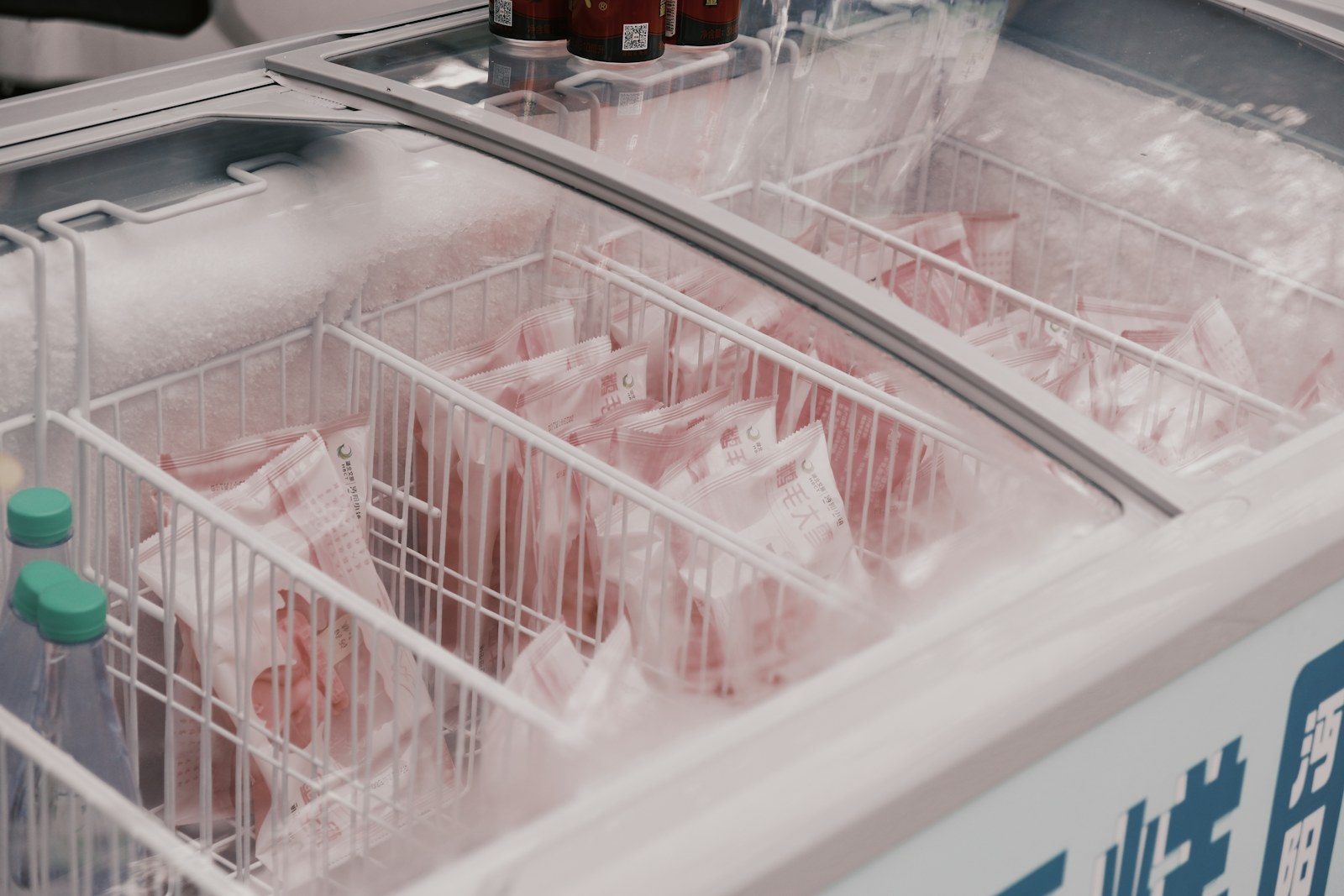 Frost-lined commercial chest freezer with frozen product in wire baskets